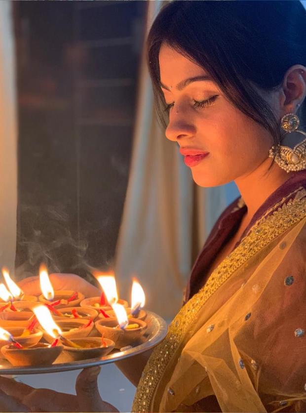 An young and beautiful Indian Bengali woman in Indian traditional dress is  holding a Diwali diyalamp in her hand in front of colorful bokeh lights  Stock Photo  Alamy